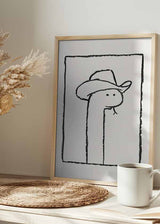 Cuadro de serpiente con sombrero vaquero, líneas negras sobre fondo blanco y composición limpia de estilo ilustración. Disponible en kudeko.com