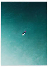 Wandbild mit einsamem Surfer auf weißem Surfbrett in türkisfarbenem und blaugrünem Meer, mit Luftperspektive und klarer Bildsprache im fotografischen Stil. Erhältlich auf kudeko.com