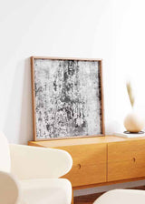 Tableau carré avec composition abstraite en blanc, gris et noir, texture usée, taches irrégulières et style contemporain pour une décoration murale sobre. Disponible sur kudeko.com