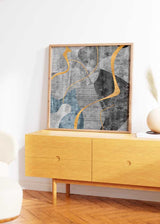Quadratisches Wandbild mit organischen abstrakten Formen in Grau, Schwarz, Weiß, Graublau und geschwungenen Linien in Senfgelb, im modernen abstrakten Stil. Erhältlich auf kudeko.com