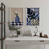 Tableau encadré avec feuilles tropicales abstraites en bleu marine, bleu cobalt, gris lavande, blanc et noir, dans une composition botanique moderne au style abstrait. Disponible sur kudeko.com