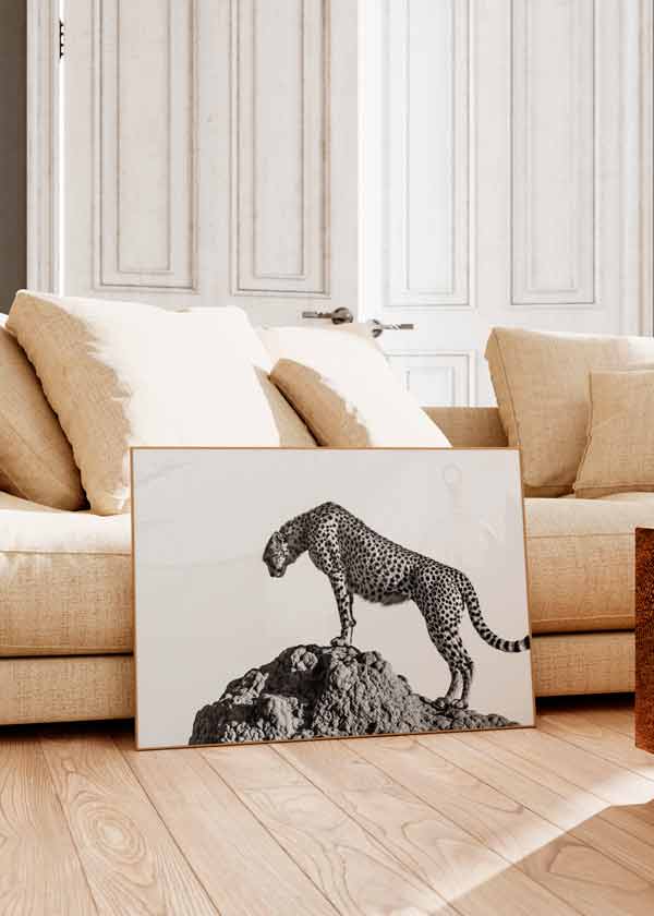 Horizontales Wandbild mit Gepard in Schwarz-Weiß auf einem Felsen, geflecktes Fell, heller Hintergrund, sachlicher fotografischer Tierstil mit klarer Komposition. Erhältlich auf kudeko.com