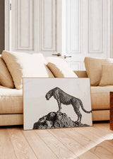Horizontales Wandbild mit Gepard in Schwarz-Weiß auf einem Felsen, geflecktes Fell, heller Hintergrund, sachlicher fotografischer Tierstil mit klarer Komposition. Erhältlich auf kudeko.com