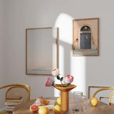 Cuadro de entrada de librería con puerta negra, arco de piedra, fachada melocotón y detalle urbano de estilo fotográfico. Disponible en kudeko.com