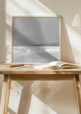 Cuadro cuadrado de paisaje costero en tonos grises, blancos y azulados, con agua serena, reflejos suaves y montañas difusas al fondo, de estilo naturaleza y paisajes. Disponible en kudeko.com