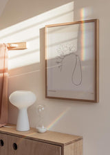 Cuadro de flores de línea fina con silueta orgánica alargada, fondo blanco roto, detalles beige suaves y estilo minimalista. Disponible en kudeko.com