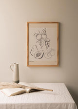 Cuadro de frutas tropicales y cítricos con limones, papaya, pera y naranjas, en negro sobre fondo beige, estilo ilustración botánica. Disponible en kudeko.com
