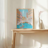 Wandbild mit einer Szene aus Venedig, Gondel auf türkisfarbenem Kanal, weißer Brücke, Campanile und Fassaden in Korall, Pfirsich und Creme, im Illustrationsstil. Erhältlich auf kudeko.com