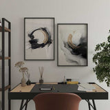Quadro com grande forma circular em preto e bege, fundo branco pérola, composição abstrata com salpicos, traços largos e estilo contemporâneo minimalista. Disponível em kudeko.com