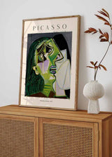 Cuadro con retrato cubista de mujer llorando, rostro anguloso en tonos verdes, negro, crema y lila, composición expresiva de estilo ilustración. Disponible en kudeko.com