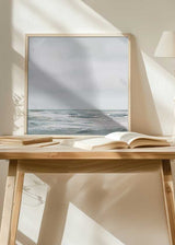 Quadratisches Wandbild mit Meereslandschaft, offenem Horizont, ruhigem Wasser, diffusen Felsen in Weiß, Perlgrau und Blaugrün, im Stil Natur und Landschaften mit klarer, zeitgenössischer Wirkung. Erhältlich auf kudeko.com