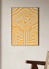 Gerahmtes Wandbild mit abstrakter Blume in Senfgelb und Weiß, wellenförmigen Linien, klarer grafischer Komposition und modernem Illustrationsstil. Erhältlich auf kudeko.com