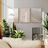 Quadro emoldurado de beira-mar com espuma branca, areia bege, subtis tons azul-turquesa e estilo natureza e paisagem sereno. Disponível em kudeko.com