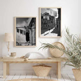 Cuadro escena urbana en blanco y negro con niña saltando a la comba, edificios antiguos, ropa tendida y fuerte luz lateral, de estilo fotográfico. Disponible en kudeko.com