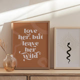 decoración con cuadros, ideas - Cuadro con frase "Love her, but leave her wild" con fondo rojizo y naranja