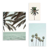 Ensemble de trois tableaux avec palmiers tropicaux, horizon marin, ciel bleu doux, tons vert grisé et noir, dans un style photographique à l’esprit côtier apaisé. Disponible sur kudeko.com