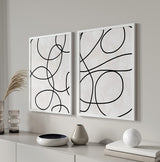 Conjunto de dos cuadros abstractos minimalistas con líneas negras en fondo claro. kudeko.com