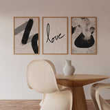 Conjunto de tres cuadros con formas abstractas negras y grises, palabra love en negro y fondo beige suave, de estilo abstracto. Disponible en kudeko.com