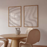 Ensemble de deux tableaux abstraits avec lignes courbes et ondulées beige doux sur fond blanc, dans un style minimaliste et épuré pour une décoration murale encadrée. Disponible sur kudeko.com