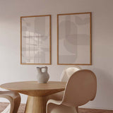 Set aus zwei Wandbildern mit abstrakten geschwungenen und rechteckigen Formen in Beige, Sand, Hellgrau und Off-White, im ausgewogenen geometrischen Stil für moderne Räume. Erhältlich auf kudeko.com