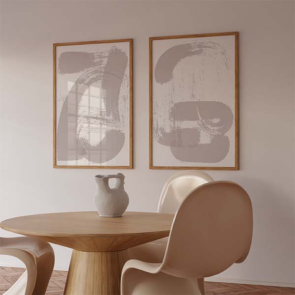 Set aus zwei gerahmten Wandbildern mit geschwungenen organischen abstrakten Formen in Graubeige auf weißem Hintergrund, im minimalistischen Stil für eine ruhige moderne Wandgestaltung. Erhältlich auf kudeko.com