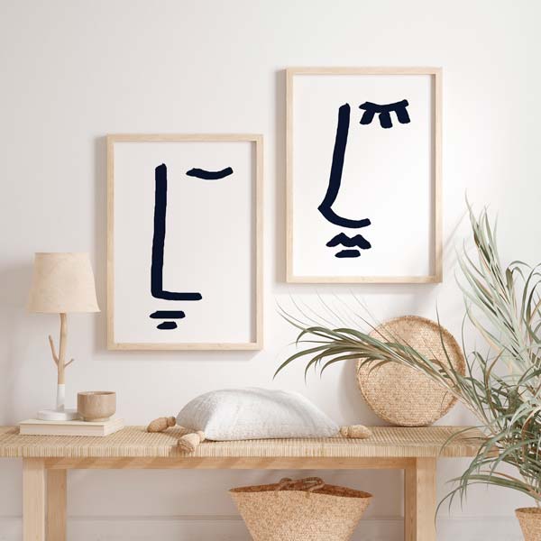 Conjunto de dos cuadros con rostros abstractos de pareja en azul marino sobre fondo blanco, composición limpia de estilo minimalista. Disponible en kudeko.com