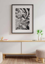 Cuadro de composición abstracta tipo graffiti sobre pared de bloques, con formas curvas en negro, blanco y gris, de estilo abstracto. Disponible en kudeko.com