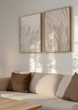 Conjunto de dois quadros com espigas suaves e folhas secas em primeiro plano, em tons de creme, bege claro e branco quebrado, composição botânica de estilo fotográfico emoldurado. Disponível em kudeko.com