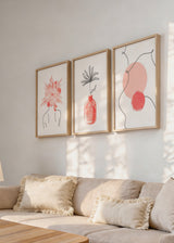 Conjunto de três quadros com flor coral sobre silhueta feminina, composição abstrata com círculos rosados, jarra delicada e flor linear preta sobre fundo branco, em estilo abstrato leve. Disponível em kudeko.com