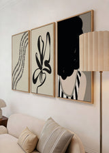 Conjunto de três quadros com linhas onduladas pretas, retrato feminino em tons de bege e cinzento, e forma orgânica abstrata de estilo minimalista contemporâneo. Disponível em kudeko.com