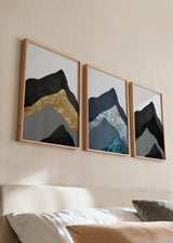 Set aus drei Wandbildern mit abstrakten, überlagerten Bergen in Schwarz, Grau, Petrolblau, Türkis und goldenen Details, im geometrischen zeitgenössischen Stil. Erhältlich auf kudeko.com
