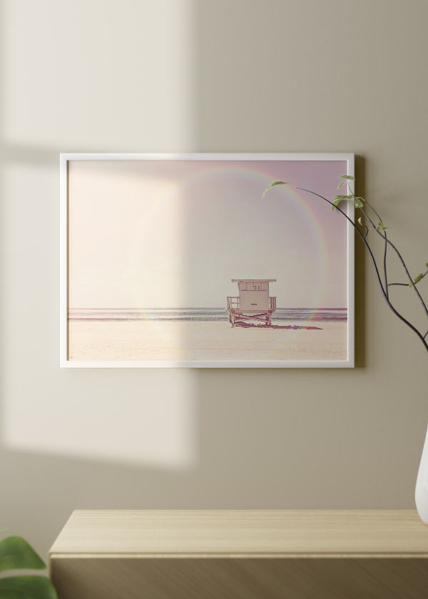 Horizontales Wandbild mit Strandhaus am Meer auf hellem Sand, zart rosa Himmel, beige Farbtönen und irisierenden Reflexen, in einem luftigen fotografischen Stil. Erhältlich auf kudeko.com