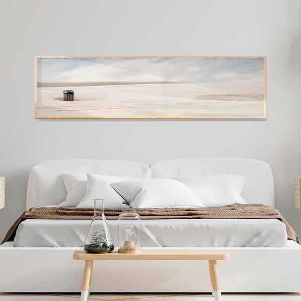 Quadro horizontal com caixote do lixo solitário numa praia deserta, areia bege clara, céu cinzento e branco suave, em estilo fotográfico minimalista e depurado. Disponível em kudeko.com