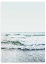 Gerahmtes Wandbild mit Meeresmotiv, sanften Wellen am Ufer, weißem Schaum, blaugrünem Wasser, nassem Sand und ruhigem fotografischem Stil. Erhältlich auf kudeko.com