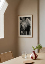 Quadro com rinoceronte em primeiro plano, corno em destaque, pele cinzenta texturada, fundo natural desfocado e estilo fotográfico elegante a preto e branco. Disponível em kudeko.com
