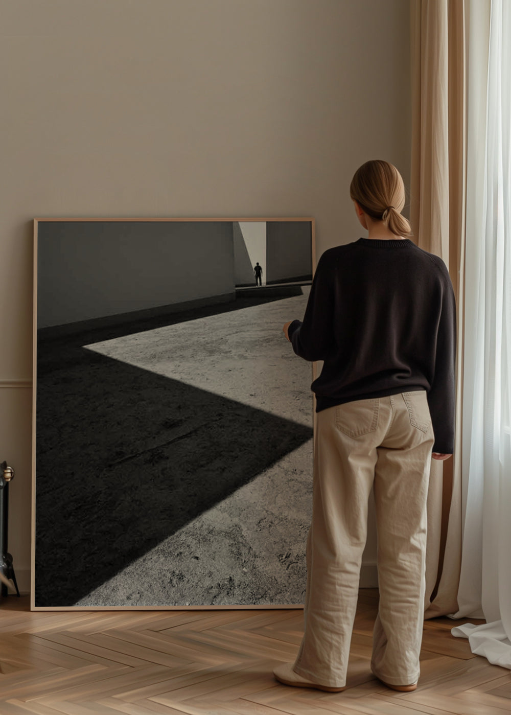 Architektonisches Wandbild in Schwarz-Weiß mit diagonalen Schatten, strukturiertem Betonboden, kleiner entfernter menschlicher Figur und zeitgenössischem fotografischem Stil. Erhältlich auf kudeko.com