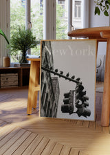 Tableau encadré avec scène urbaine de New York en noir et blanc, façade classique, feu suspendu, pigeons posés, fond clair et style photographique contemporain. Disponible sur kudeko.com