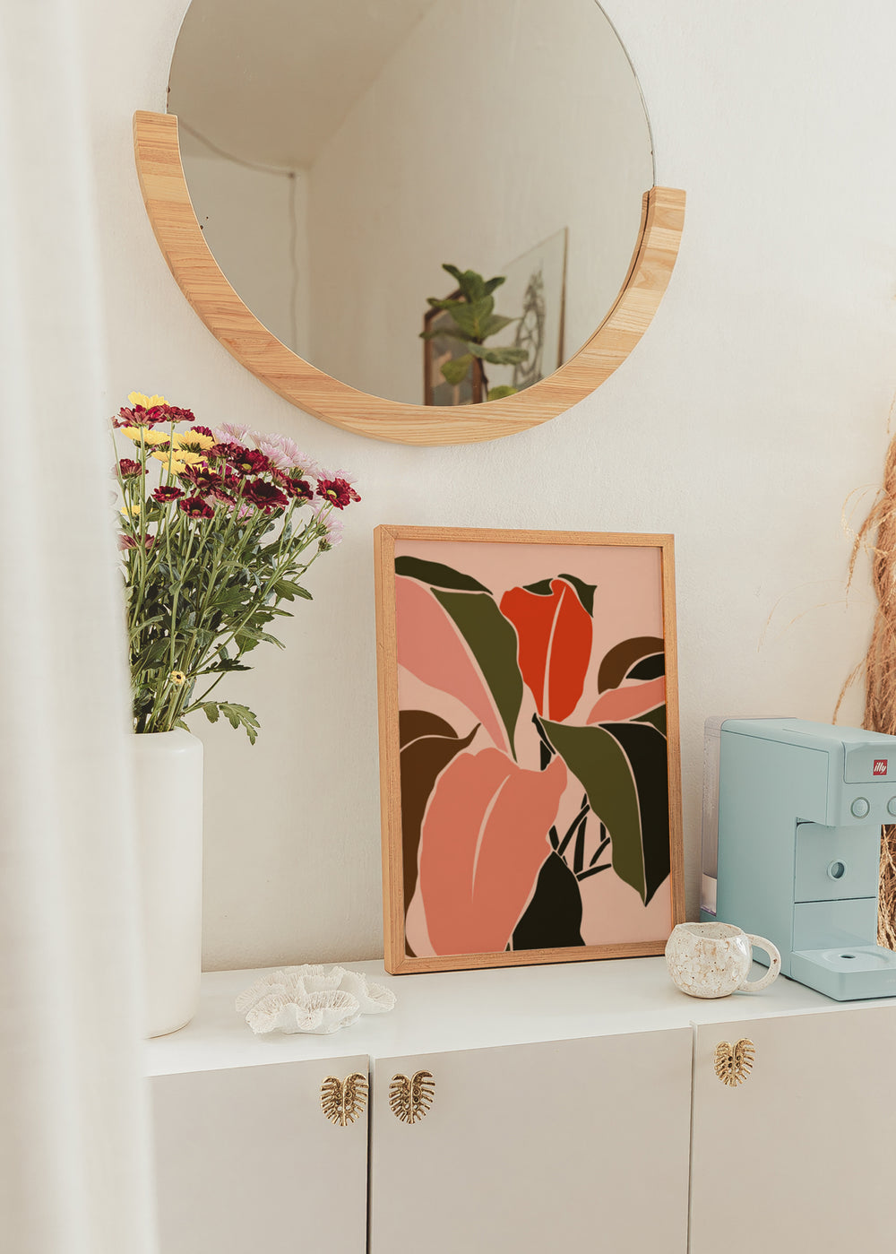 Gerahmtes Wandbild mit großen tropischen Blättern in Korall, Orangerot, Olivgrün, Dunkelbraun und Schwarz auf hellrosa Hintergrund, im zeitgenössischen floralen Stil. Erhältlich auf kudeko.com