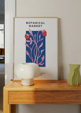Tableau encadré avec composition botanique de tiges et fruits roses, fond bleu soutenu, typographie noire et style illustration contemporaine, aux accents éditoriaux. Disponible sur kudeko.com