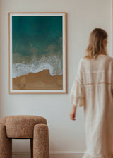 Tableau avec vue aérienne d’une côte, mer turquoise et vert profond, écume blanche, sable beige chaud, composition sereine au style photographique lumineux. Disponible sur kudeko.com