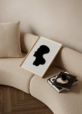 Quadro emoldurado com silhueta de rosto humano de perfil em preto, fundo bege claro e composição depurada de estilo minimalista para decoração de parede contemporânea. Disponível em kudeko.com