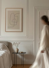 Wandbild mit durchgehenden schwarzen Linien, organischen Formen und hellbeigem Hintergrund, abstrakte minimalistische Komposition in ausgewogenen neutralen Farbtönen. Erhältlich auf kudeko.com