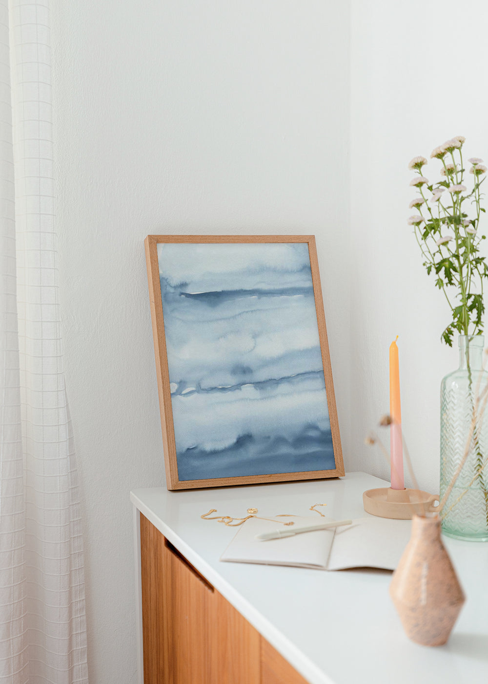 Quadro emoldurado com paisagem abstrata de horizontes difusos, neblina suave e tons de azul claro, cinzento e branco, num estilo sereno e etéreo. Disponível em kudeko.com