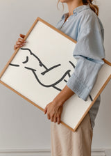 Gerahmtes Wandbild mit weiblicher Silhouette in schwarzen Linien auf weißem Hintergrund, schlichte Komposition, minimalistische Ästhetik und moderne Gestaltung für ruhige Wohnräume. Erhältlich auf kudeko.com