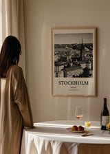 Quadro com panorama urbano de Estocolmo, telhados históricos, porto, igreja com torre alta, tons a preto e branco e estilo fotográfico elegante. Disponível em kudeko.com