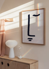 Cuadro decorativo de estilo minimalista y blanco_y_negro colocado en salón, lámina tipográfica minimalista en azul marino, modelo ÉL