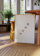 Quadro emoldurado com a palavra HOME em letras pretas dispostas na diagonal, pequeno ícone de casa, fundo branco e estilo minimalista simples e moderno. Disponível em kudeko.com