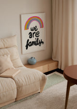Tableau encadré avec la phrase we are family en lettres noires, arc-en-ciel rose, jaune et bleu sur fond clair, style typographique pour décoration familiale. Disponible sur kudeko.com
