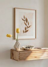 Gerahmtes Wandbild mit stilisiertem Blattzweig in Kupfer, Braun und hellem Beige, auf sanft texturiertem Hintergrund, im minimalistischen und beruhigenden Stil. Erhältlich auf kudeko.com
