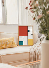 Quadro com composição geométrica de retângulos em vermelho coral, branco, azul petróleo e amarelo mostarda, destacados por linhas pretas marcantes, num estilo moderno e estruturado. Disponível em kudeko.com